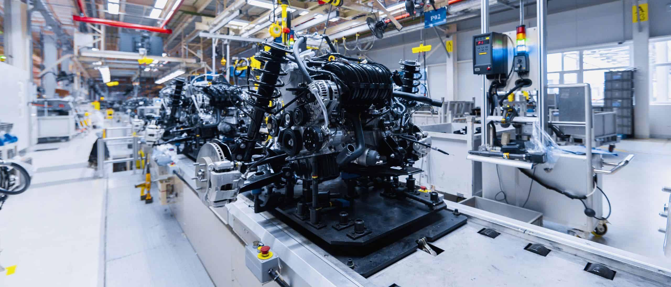 Motorenfertigung in einer modernen Automobilproduktionsanlage, hochentwickelte Montagelinie für Antriebssysteme, industrielle Automatisierung bei BOS-KG, Qualitätskontrolle im Fahrzeugbau.